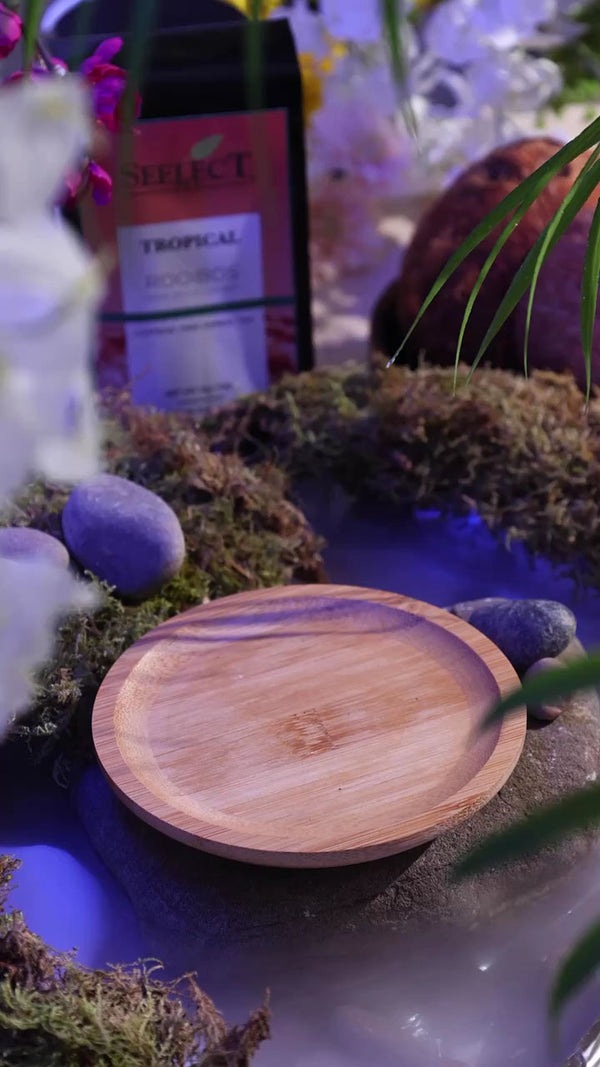 Wooden coaster on a decorative surface with a bad of tropical rooibos tea in the background